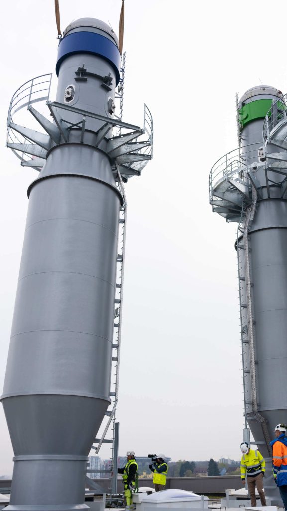 Der Kamin wurde in der Verankerung platziert, h&auml;ngt aber noch am Kran