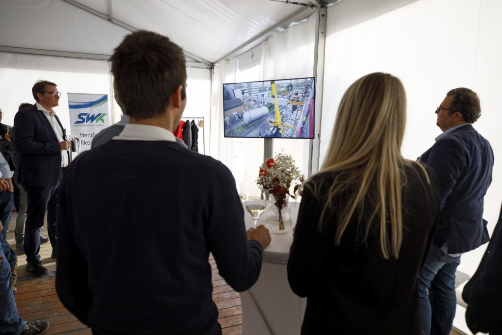 Mehrere Personen schauen ein Video &uuml;ber die Bauphase des Kraftwerks