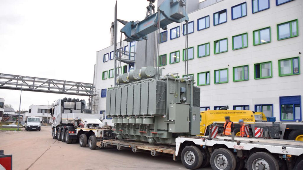Der Trafo steht auf dem Tieflader und wird an den Kran geh&auml;ngt