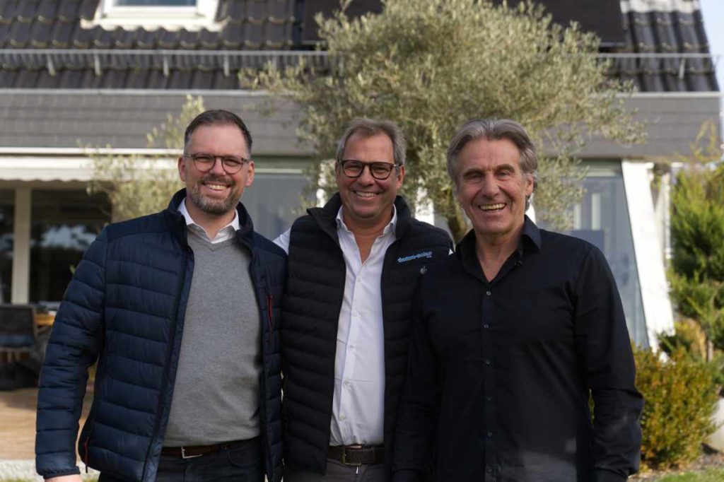 Gerry Ehrmann, füherer FCK-Torhüter steht mit Hardy Müller von damm-solar und Christian Welter von der SWK im Garten vor seinem Haus.